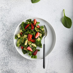 Salad with baby spinach. avocado and strawberries. Top view.