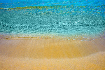 Soft wave of turquoise sea water on the sandy beach