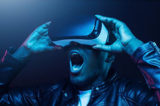 Fototapeta Close-up headshot of excited young african american man enjoying virtual reality with mouth wide open