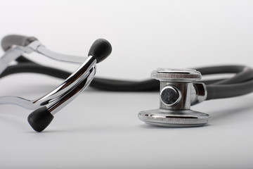 Black stethoscope on white background, close up view.