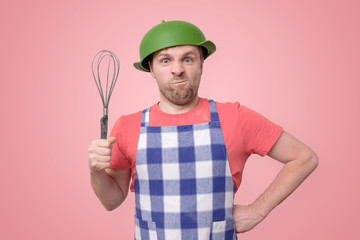 crazy man in an apron with a colander on his head