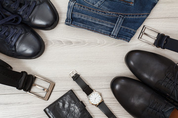 Two pairs of black leather men's shoes, two belts for men, jeans and men accessories.