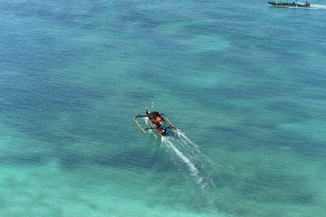 Bright blue sea and traditional boats in Bukit Merese, South Lombok, Asia