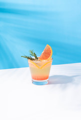Cold and refreshing orange punch cocktail with orange slice on color background. summer drink.