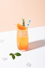 Cold and refreshing orange punch cocktail with orange slice on color background. summer drink.