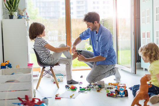 Dad Is Helping Son To Get Dressed