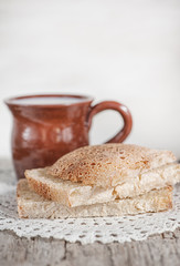 Slices of fresh bread and Cup of milk on the old table