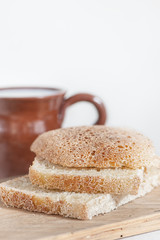 Slices of fresh bread and Cup of milk on the old table