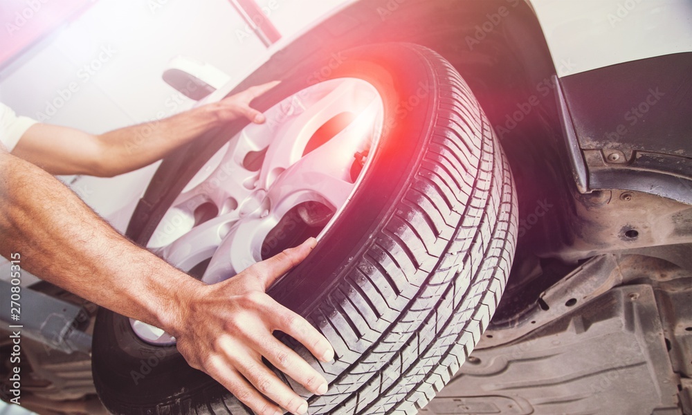 Wall mural male hands with automobile tires on background