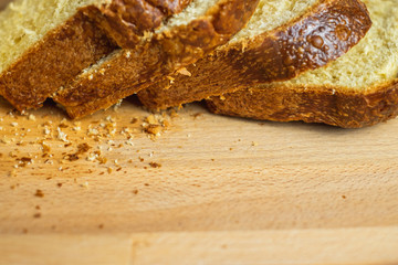 Slice Brioche toast loaf with bread crumbs on wood cutting board