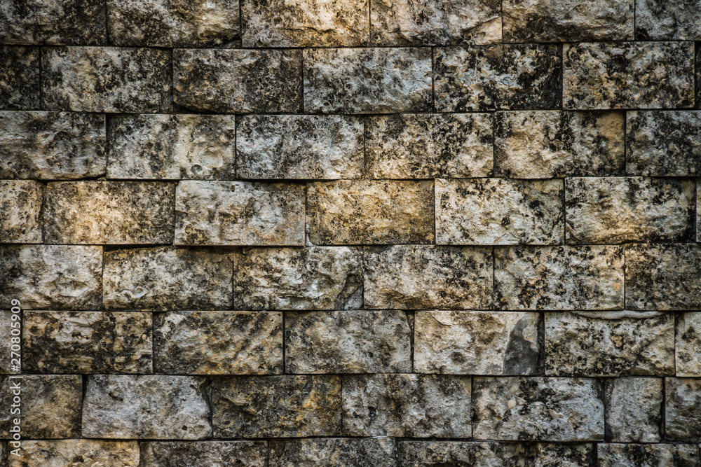 Poster A background image consisting of aged and weathered grungy bricks with spots of sunlight on them.