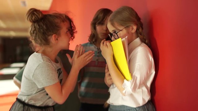 Girl hooligan insults his classmate honors pupil. Snatches her glasses and a book. Physical abuse among adolescents. The victim is running away