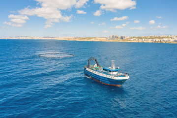 Fototapeta na wymiar Fishing vessel boat floating in the blue sea along the coast.