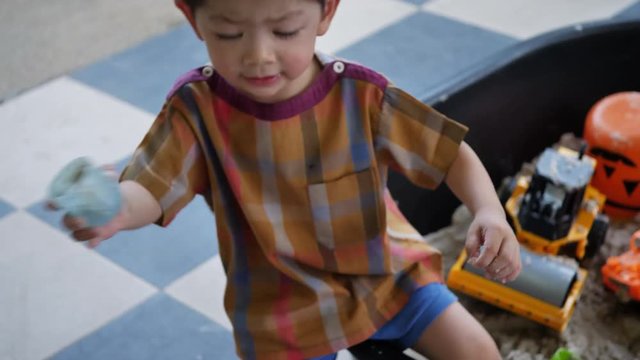 happy child playing toy in sand playground