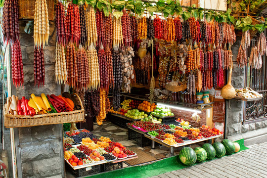 Georgia, the local bazaar. Sale of national sweets from grapes and nuts - "Churchkhela", fresh and dried fruits and vegetables