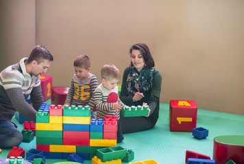 Fototapeta premium young parents and kids having fun at childrens playroom