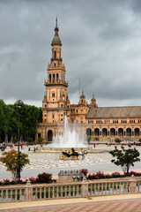 Fototapeta na wymiar North tower and Vicente Traver fountain with horse and carriage at Plaza de Espana Seville