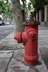 Fototapeta na wymiar Red fire hydrant without top lid on concrete sidewalk i ity, Shanghai