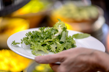 hands add salad on a plate in a restaurant brunch