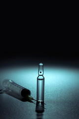medical ampoules and syringe isolated on dark blue turquoise background