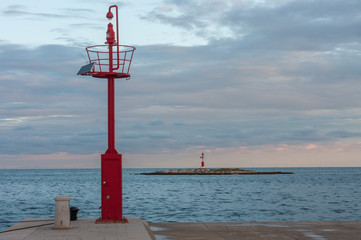 Steel lookout on pier, on background cloudy sky and sea lighthouse