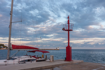 Sailboat, lookout on pier at sunrise time.