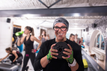 sporty woman holding a metal round weights plate