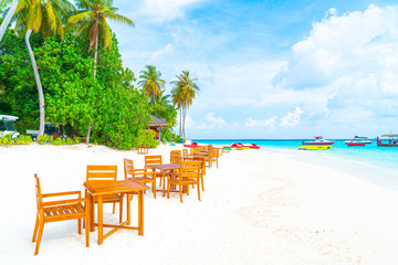 wood table and chair on beach with sea view background in Maldives