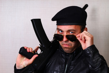 Young man in black leather jacket with assault rifle