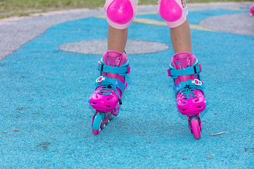 Little girl playing with roller skates
