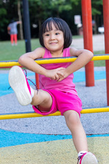 Fototapeta na wymiar Asian Chinese little girl climbing at outdoor playground