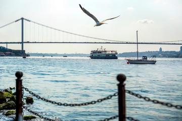 Muslim architecture and water transport in Turkey - Beautiful View touristic landmarks from sea voyage on Bosphorus. Cityscape of Istanbul at sunset - old mosque and turkish steamboats, view on Golden