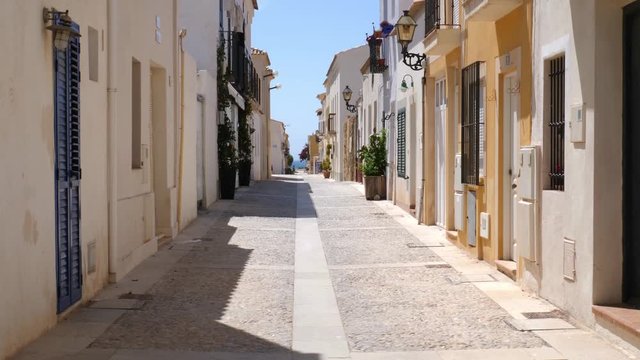 Beautiful alley in the old spanish village on the small island Tabarca off the coast of Alicante in sunshine and blue sky.