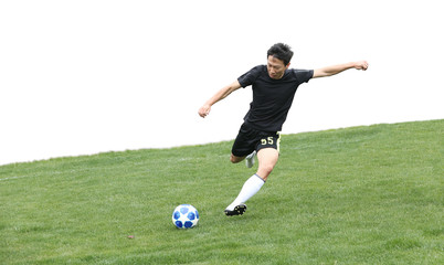 Asian soccer player kicking ball isolated on white © allensima