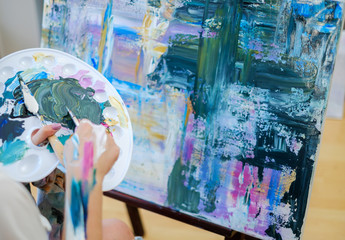 Creative painter paints a colorful picture in her studio