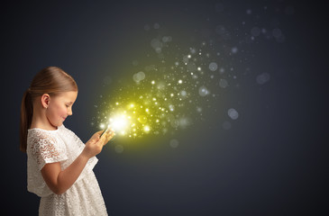 Little cute girl playing on sparkling tablet                         