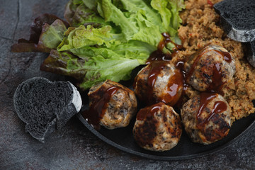 Fried truffles made of mushrooms and cheese with kuskus and salad leaves, close-up, studio shot