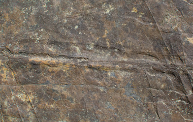 The texture of the stone. Multicolored brown. Natural background. Cracks and scratches