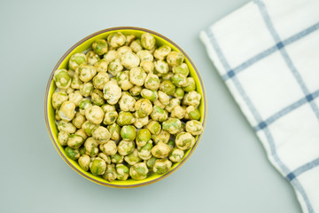 Crispy green peas in green ceramic bowl