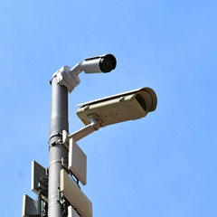 security cameras two pieces against a blue sky