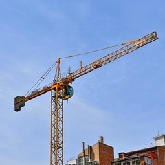 construction crane above the houses against the sky