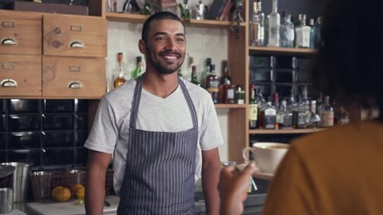 Male barista serving coffee to the customer at counter - Powered by Adobe