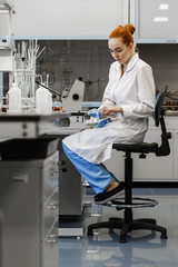 Naklejka premium red-haired woman works in the medical laboratory