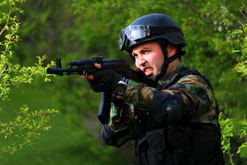 A special forces soldier in the forest with a rifle storms opponents.