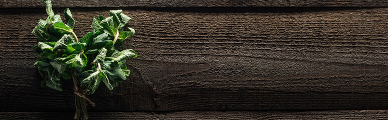 panoramic shot of green fresh mint on wooden rustic table