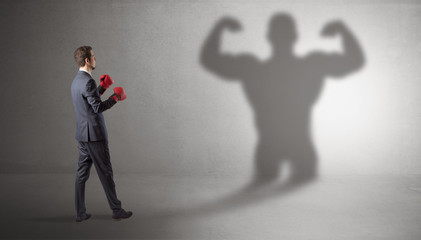 Businessman fighting with his bossy yelling shadow
