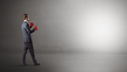 Obraz premium Businessman fighting with boxing gloves in an empty space 