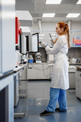 red-haired woman works in the medical laboratory