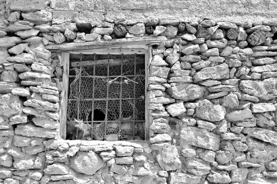 Vieja ventana en una antigua casa de piedra