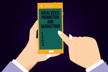Writing note showing Viral Video Promotion And Marketing. Business photo showcasing Modern advertising social media strategy Hu analysis Hands Holding Pointing Smartphone Blank Color Screen